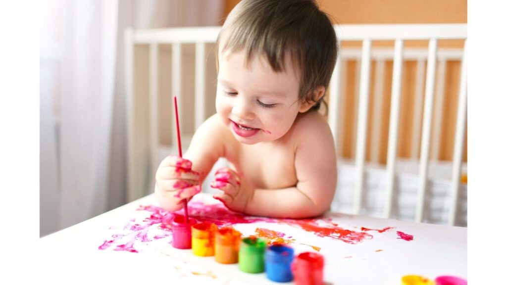 赤ちゃんが絵の具アートをしている写真